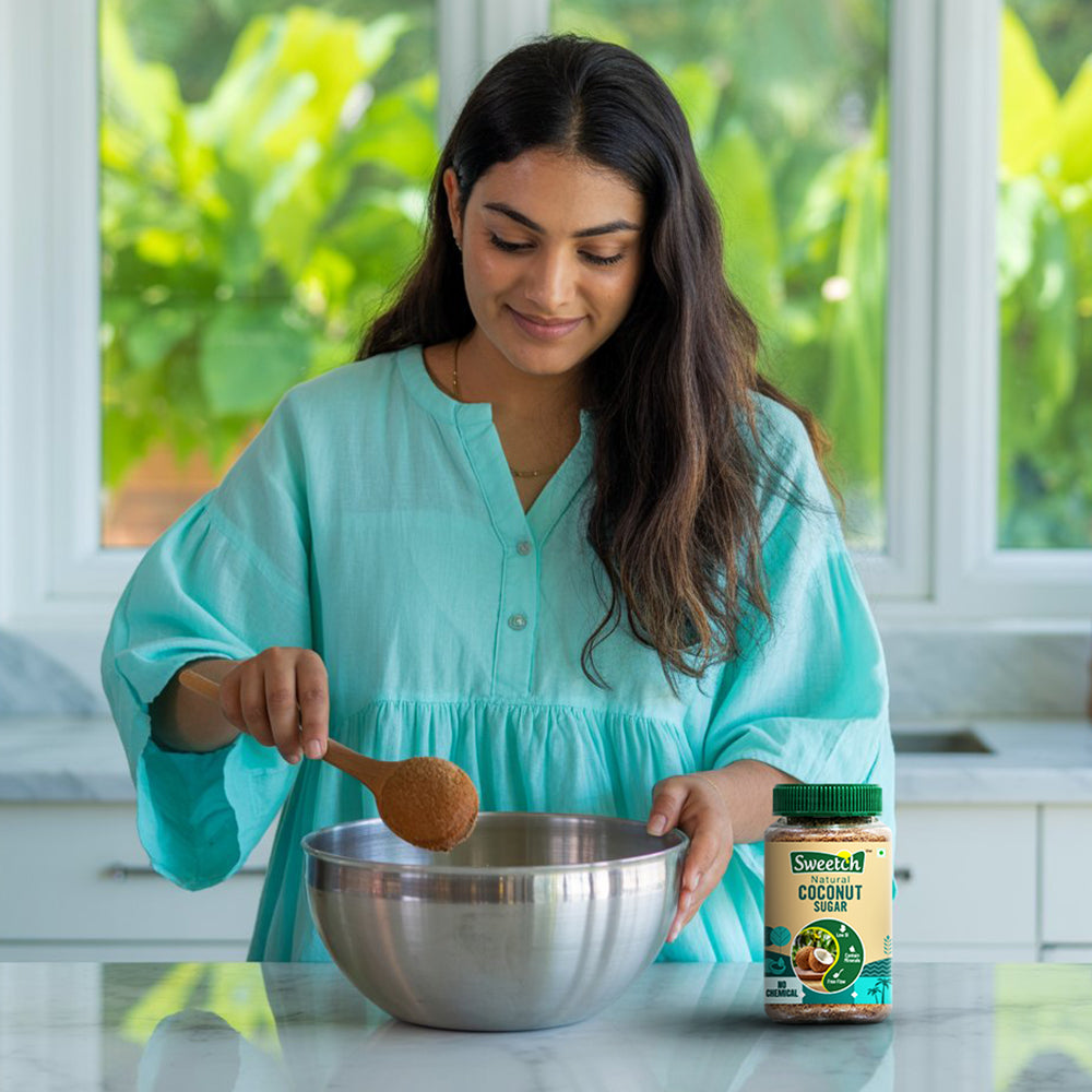 Woman in a kitchen stirring a bowl with a wooden spoon, using sweetch natural coconut sugar.